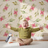 Lovely child standing in front of Whimsy Tots Whimsy Bloom Sprays Wallpaper in Cream with flower, leaf, bloom, spray in design. Lovely child standing in front of Whimsy Tots Whimsy Bloom Sprays Wallpaper in Cream with flower, leaf, bloom, spray in design.