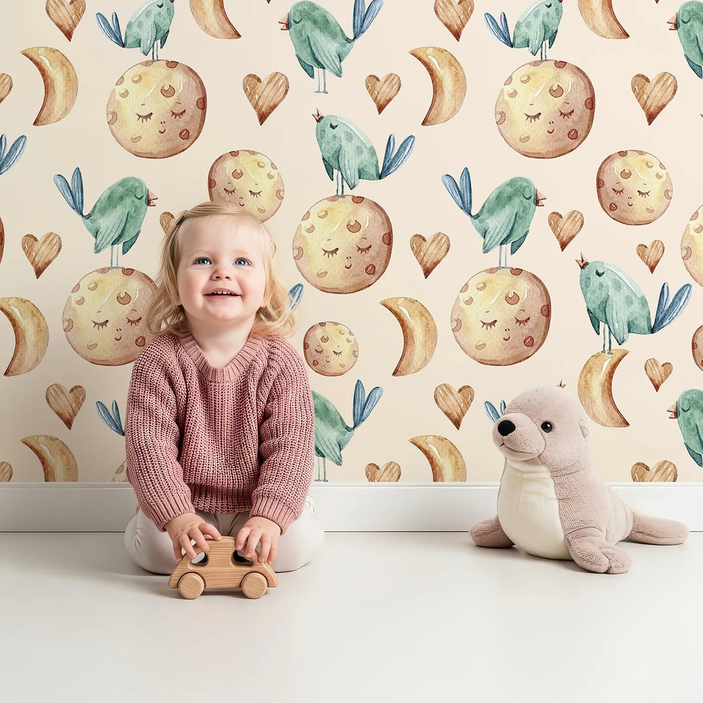Lovely child standing in front of Whimsy Tots Moon Melody Wallpaper in Cream with bird, moon, heart, star in design.