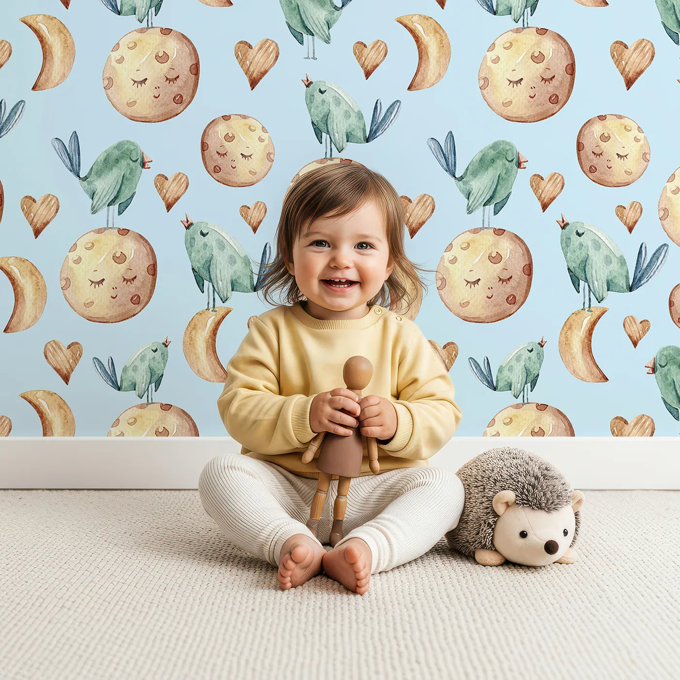 Lovely child standing in front of Whimsy Tots Moon Melody Wallpaper in Sky with bird, moon, heart, star in design.