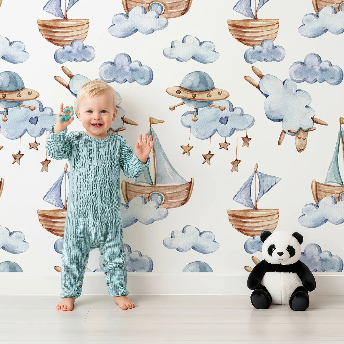 Lovely child standing in front of Whimsy Tots Cloud Sailor Dreams Wallpaper in White with ship, cloud, sheep, star, sail in design.