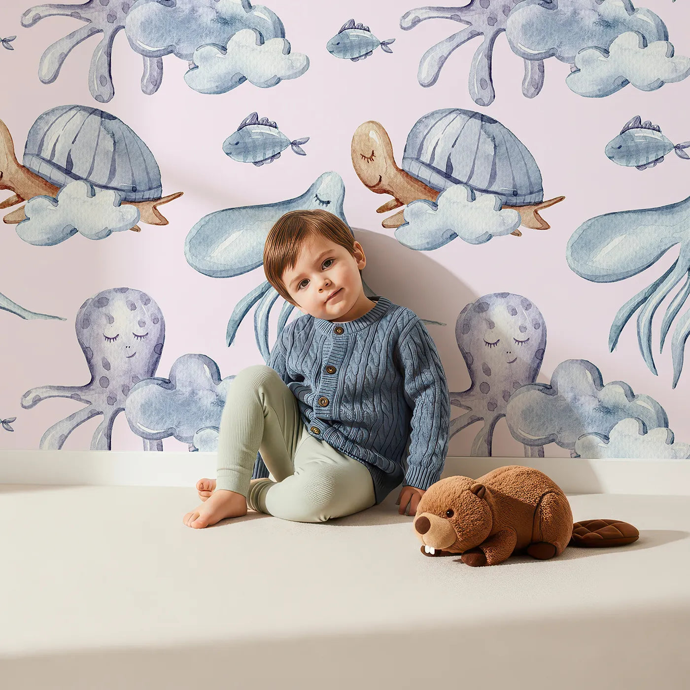 Lovely child standing in front of Whimsy Tots Ocean Dreams Wallpaper in Blush Pink with cloud, turtle, octopus, squid, fish in design.