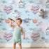 Lovely child standing in front of Whimsy Tots Whales of Love Wallpaper in Blue with whale, balloon, heart, lighthouse, bear, fish in design. Lovely child standing in front of Whimsy Tots Whales of Love Wallpaper in Blue with whale, balloon, heart, lighthouse, bear, fish in design.