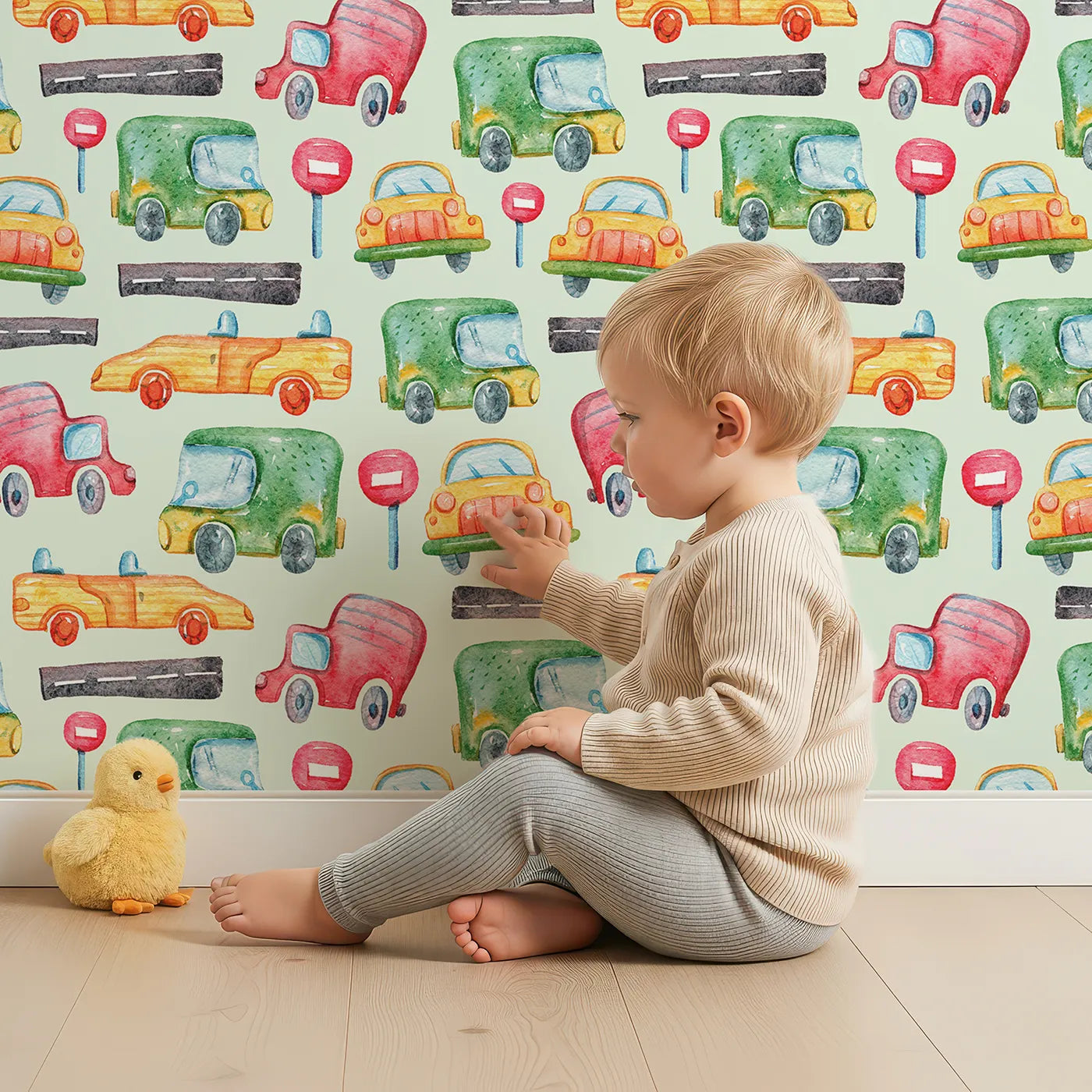 Lovely child standing in front of Whimsy Tots Little Car Parade Wallpaper in Mint Green with car, sign, road in design.