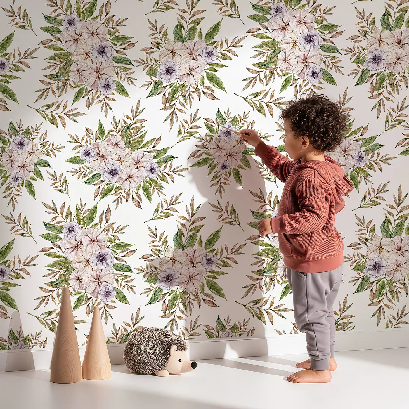 Lovely child standing in front of Whimsy Tots Meadow Petal Cluster Wallpaper with flower, leaf, petal in design.
