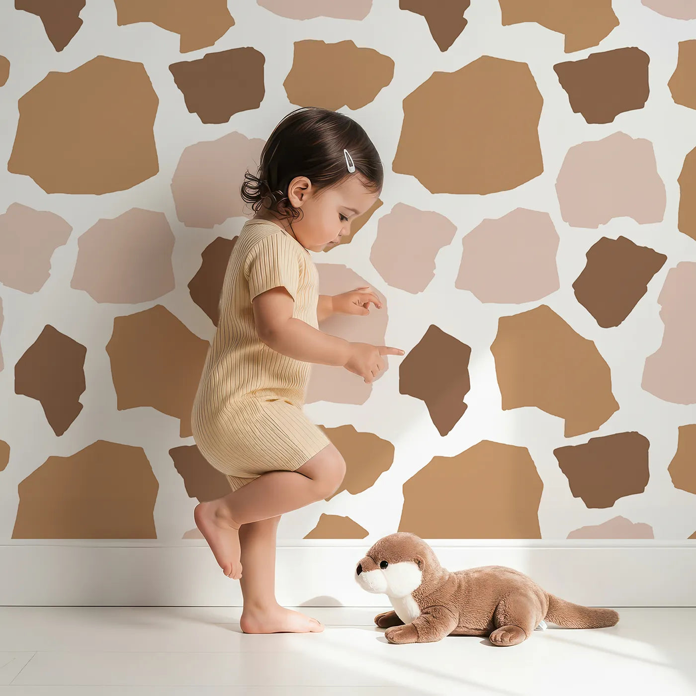 Lovely child standing in front of Whimsy Tots Savanna Giraffe Spots Wallpaper with spot, shape, giraffe in design.