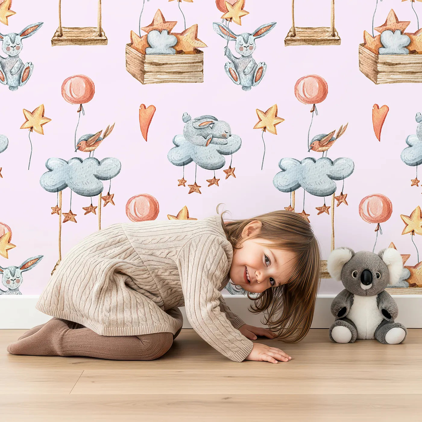 Lovely child standing in front of Whimsy Tots Dreamland Friends Wallpaper in Pink with bird, bunny, cloud, balloon, star in design.