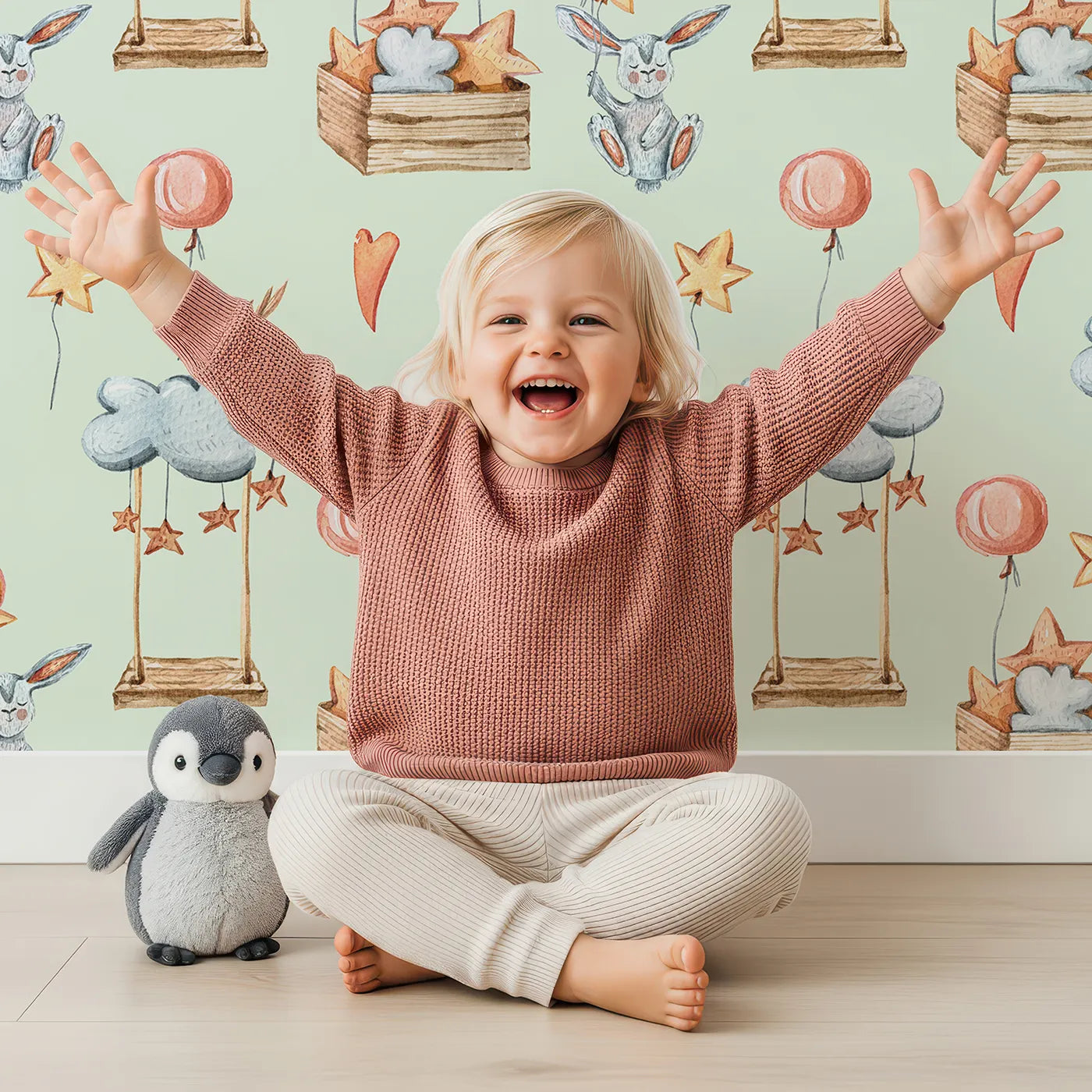 Lovely child standing in front of Whimsy Tots Dreamland Friends Wallpaper in Mint Green with bird, bunny, cloud, balloon, star in design.