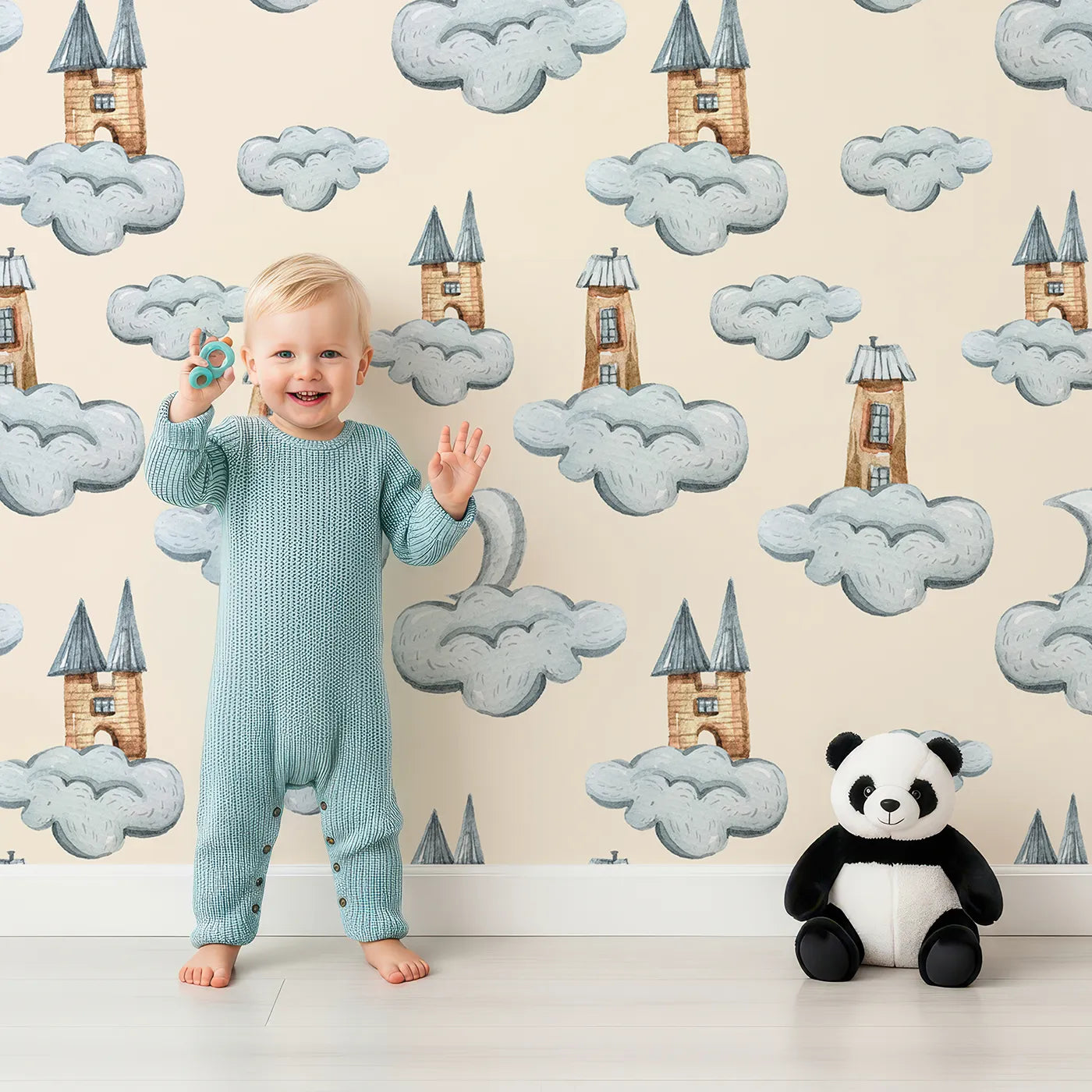 Lovely child standing in front of Whimsy Tots Castle Cloud Drift Wallpaper in Beige with castle, cloud, moon in design.