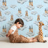Lovely child standing in front of Whimsy Tots Castle Cloud Drift Wallpaper in Blue with castle, cloud, moon in design. Lovely child standing in front of Whimsy Tots Castle Cloud Drift Wallpaper in Blue with castle, cloud, moon in design.
