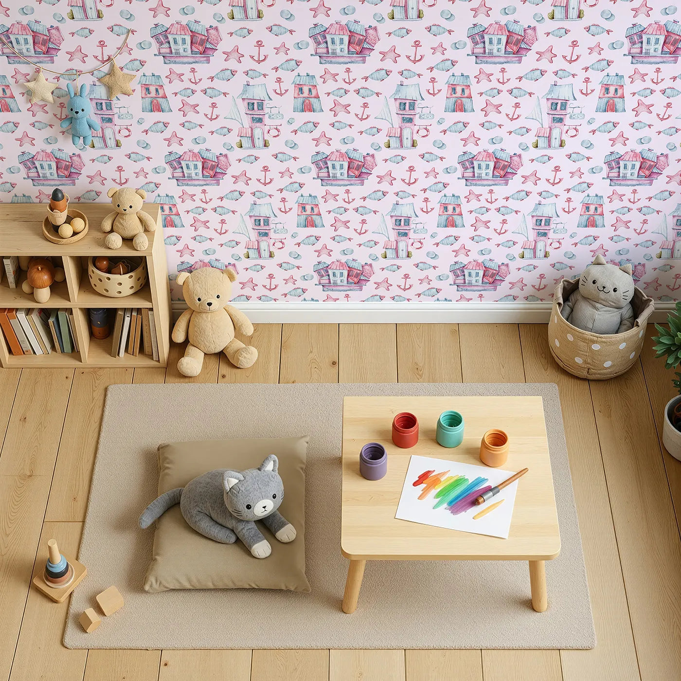 Top-Down view of Whimsy Tots' Seaside Village Parade Wallpaper in Pink (W3320B).Charming houses and cheerful sea creatures play across a pink seaside dream.