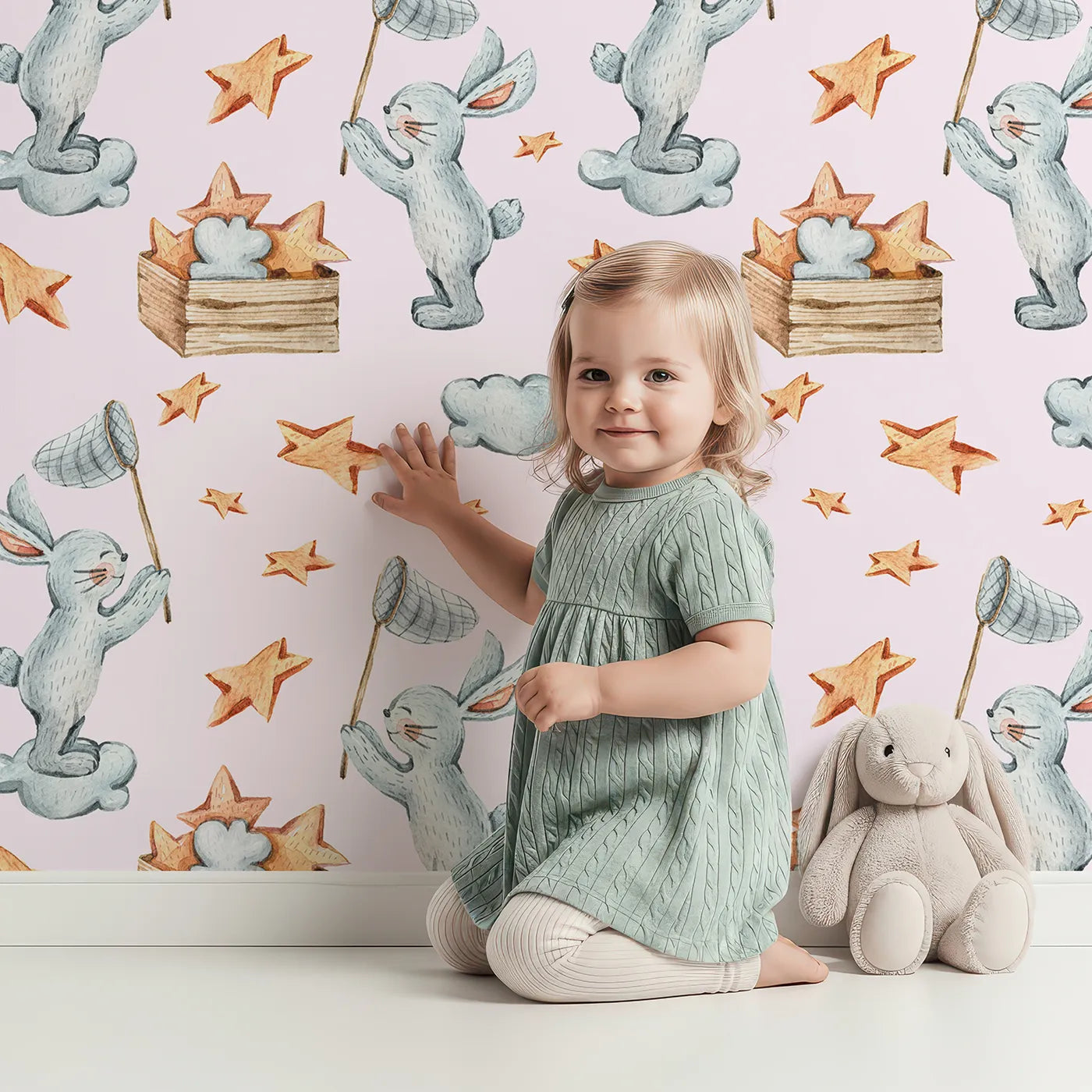 Lovely child standing in front of Whimsy Tots Star Catcher Bunnies Wallpaper in Pink with rabbit, star, cloud, net in design.