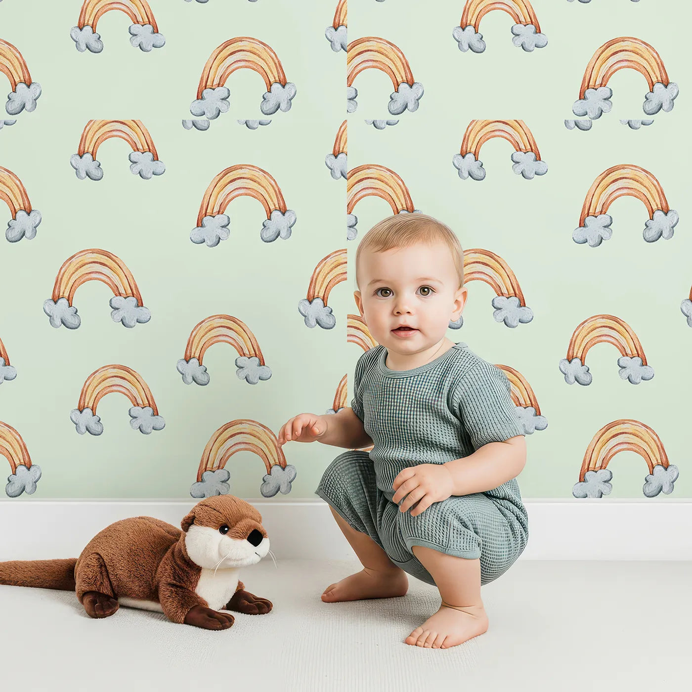 Lovely child standing in front of Whimsy Tots Sunset Rainbows Wallpaper in Green with rainbow, cloud in design.