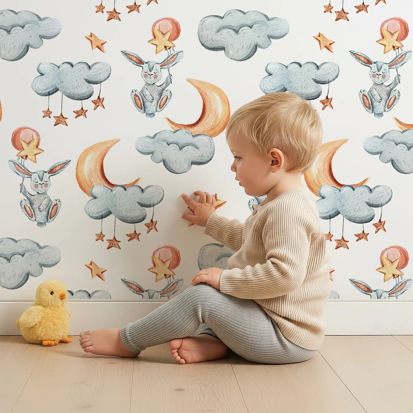 Lovely child standing in front of Whimsy Tots Moonlight Bunny Dreams Wallpaper in White with rabbit, balloon, moon, star, cloud in design.