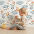 Lovely child standing in front of Whimsy Tots Moonlight Bunny Dreams Wallpaper in White with rabbit, balloon, moon, star, cloud in design. Lovely child standing in front of Whimsy Tots Moonlight Bunny Dreams Wallpaper in White with rabbit, balloon, moon, star, cloud in design.