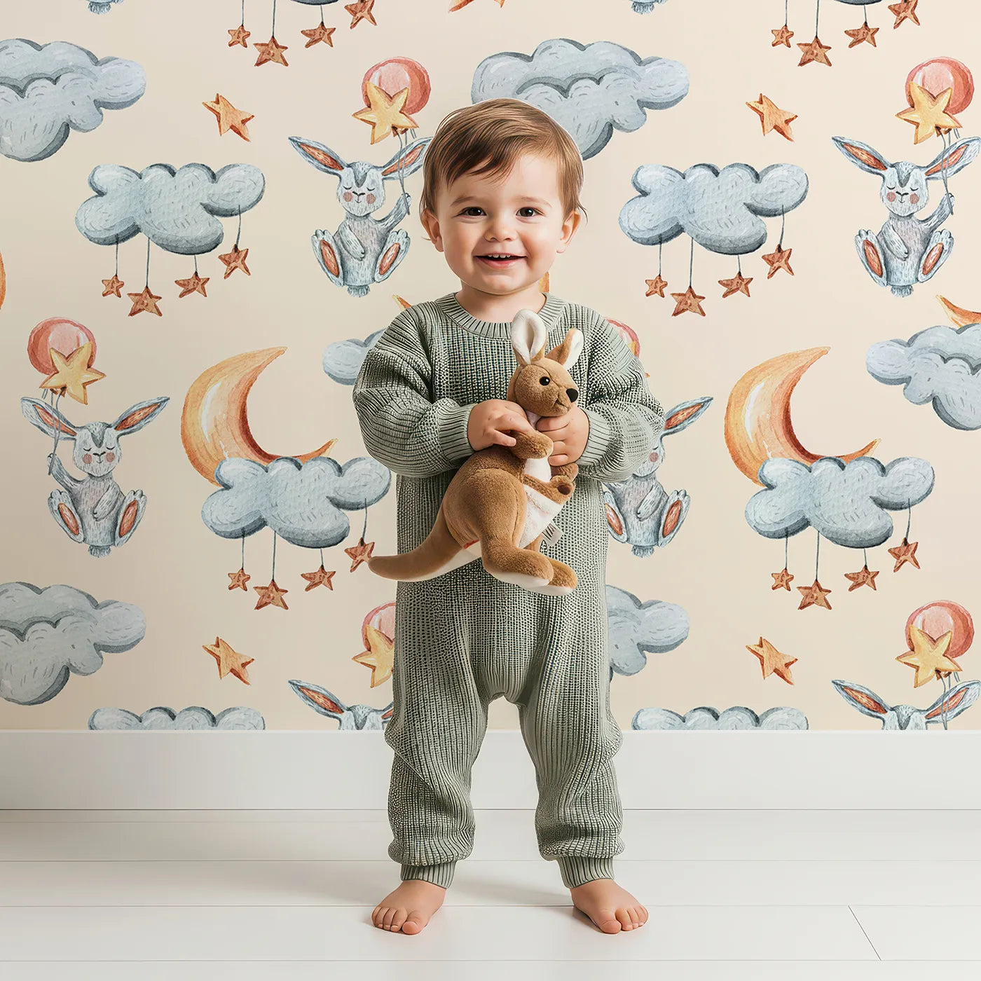Lovely child standing in front of Whimsy Tots Moonlight Bunny Dreams Wallpaper in Beige with rabbit, balloon, moon, star, cloud in design.