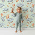 Lovely child standing in front of Whimsy Tots Moonlight Bunny Dreams Wallpaper in Green with rabbit, balloon, moon, star, cloud in design. Lovely child standing in front of Whimsy Tots Moonlight Bunny Dreams Wallpaper in Green with rabbit, balloon, moon, star, cloud in design.