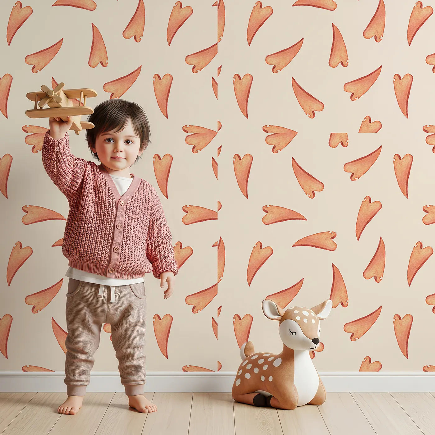 Lovely child standing in front of Whimsy Tots Scattered Heart Sprinkles Wallpaper in Cream with heart, brushstroke, splash in design.