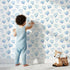 Lovely child standing in front of Whimsy Tots Blue Hearts Wallpaper in White with heart, outline, watercolor in design. Lovely child standing in front of Whimsy Tots Blue Hearts Wallpaper in White with heart, outline, watercolor in design.