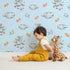 Lovely child standing in front of Whimsy Tots Bunny Cloud Dreams Wallpaper in Sky with bunny, cloud, star, string, moon in design. Lovely child standing in front of Whimsy Tots Bunny Cloud Dreams Wallpaper in Sky with bunny, cloud, star, string, moon in design.