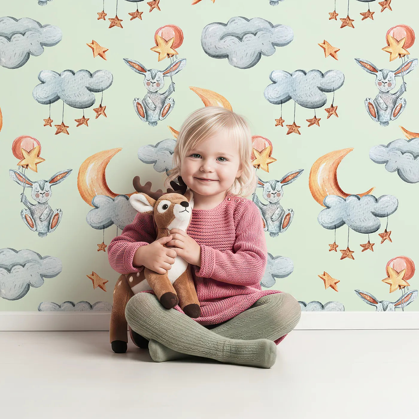 Lovely child standing in front of Whimsy Tots Starry Bunny Balloons Wallpaper in Mint Green with bunny, balloon, star, cloud, moon in design.
