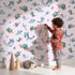 Lovely child standing in front of Whimsy Tots Gentle Sea Friends Wallpaper in Pink with whale, turtle, dolphin, fish, coral, seashell, seaweed, star in design. Lovely child standing in front of Whimsy Tots Gentle Sea Friends Wallpaper in Pink with whale, turtle, dolphin, fish, coral, seashell, seaweed, star in design.