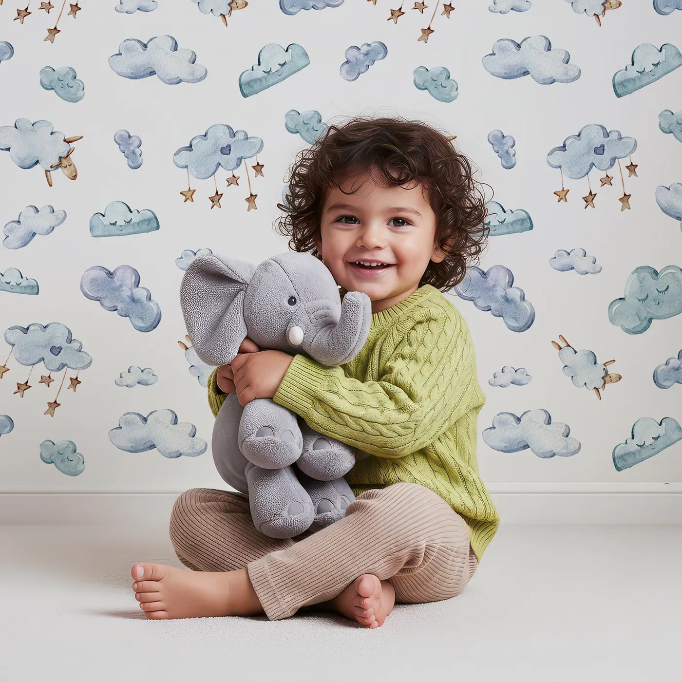 Lovely child standing in front of Whimsy Tots Counting Cloud Sheep Wallpaper in White with cloud, sheep, star, mobile in design.