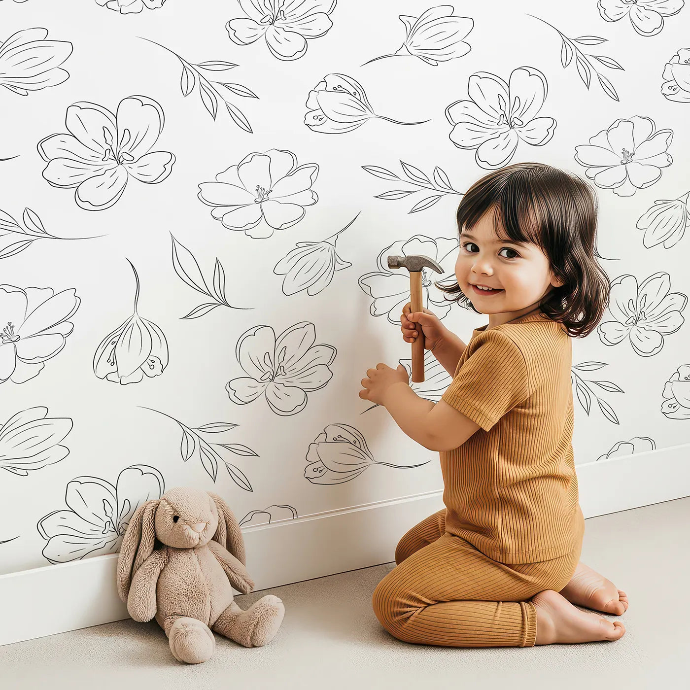 Lovely child standing in front of Whimsy Tots Line Art Bloom Wallpaper in White with flower, blossom, lineart, leaf in design.