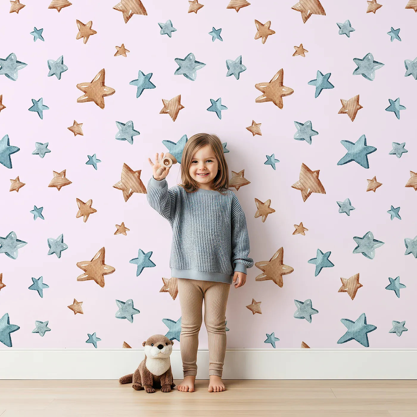 Lovely child standing in front of Whimsy Tots Starry Drift Wallpaper in Pink with star, watercolor, sky, night in design.