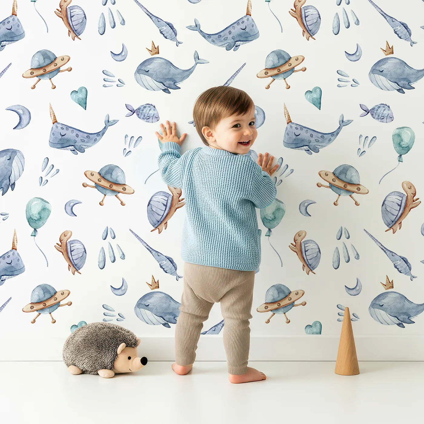 Lovely child standing in front of Whimsy Tots Ocean Galaxy Friends with whale, turtle, ufo, balloon, moon, fish, splash, star, narwhal in design.