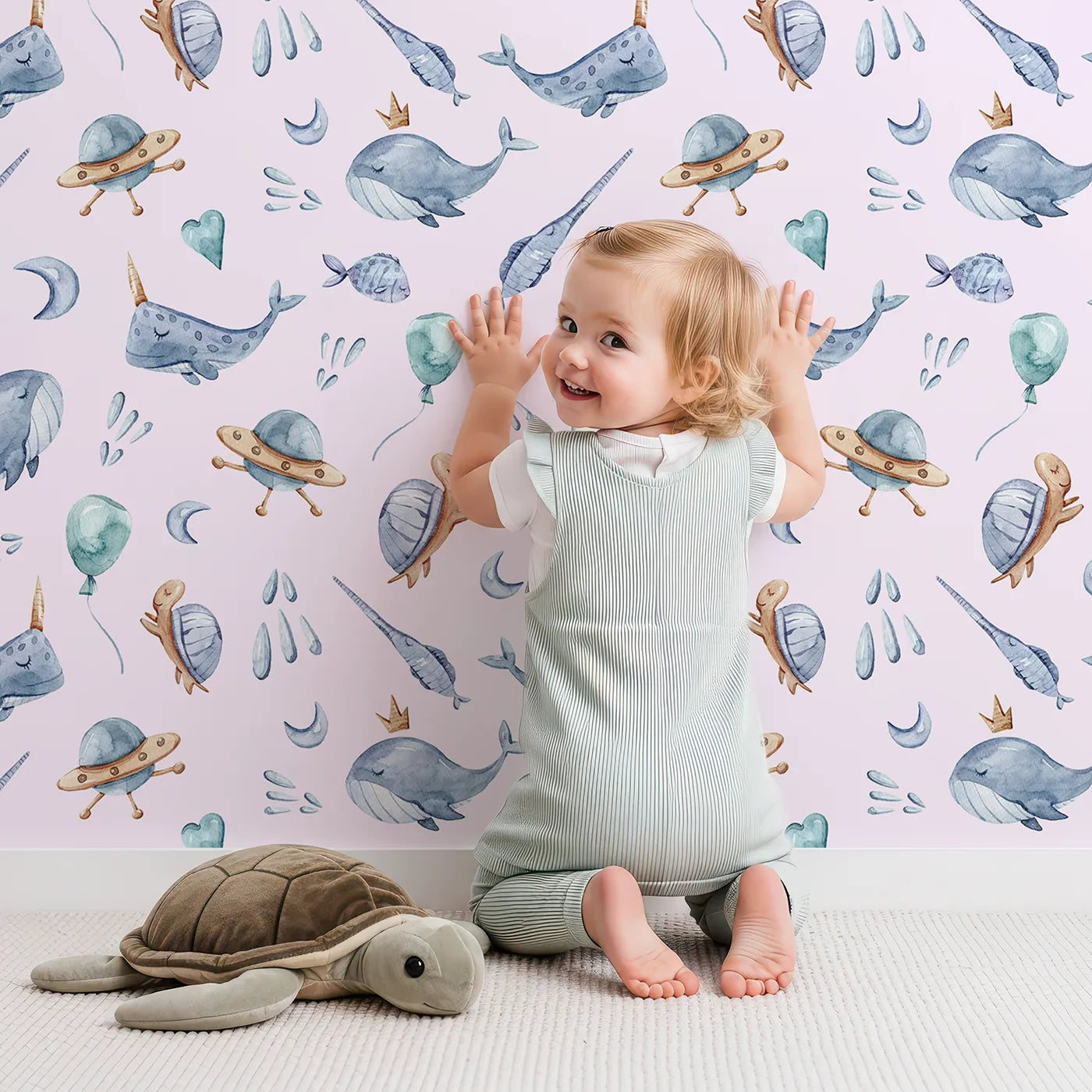 Lovely child standing in front of Whimsy Tots Ocean Galaxy Friends in Blush Pink with whale, turtle, ufo, balloon, moon, fish, splash, star, narwhal in design.