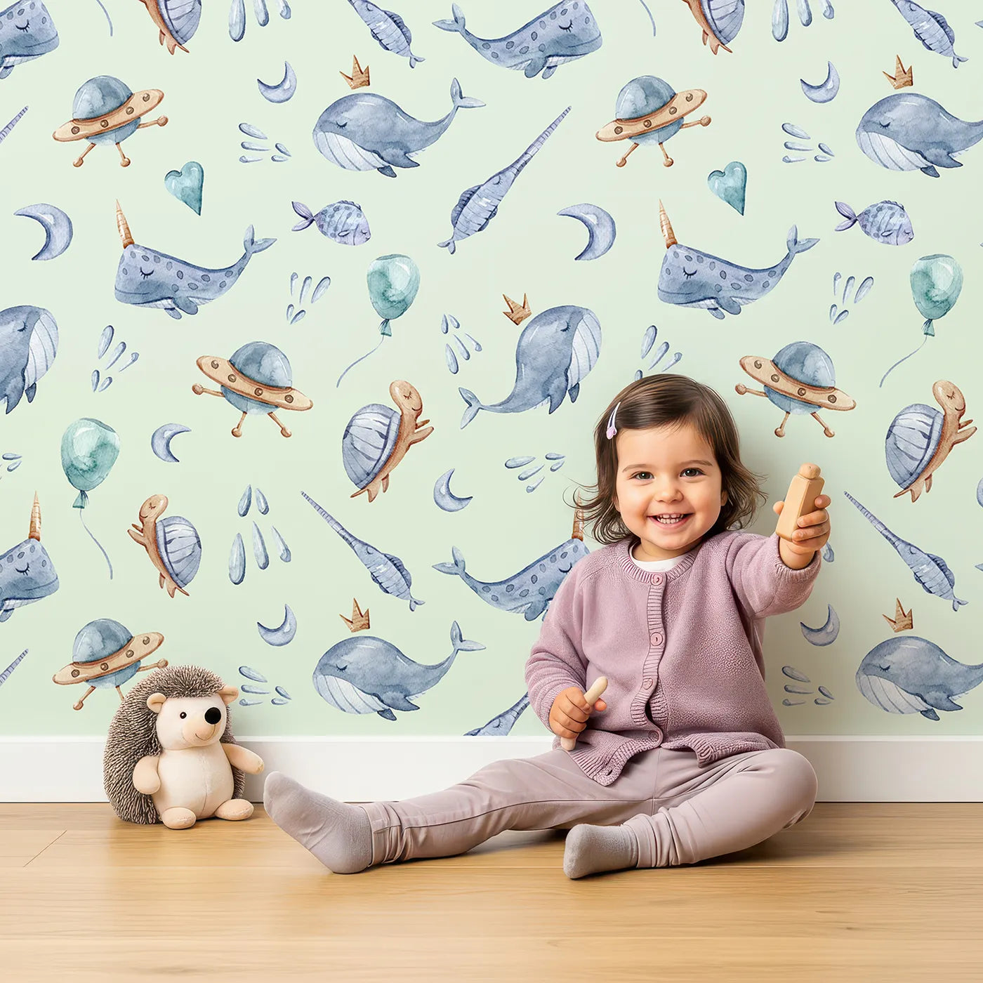 Lovely child standing in front of Whimsy Tots Ocean Galaxy Friends in Mint Green with whale, turtle, ufo, balloon, moon, fish, splash, star, narwhal in design.