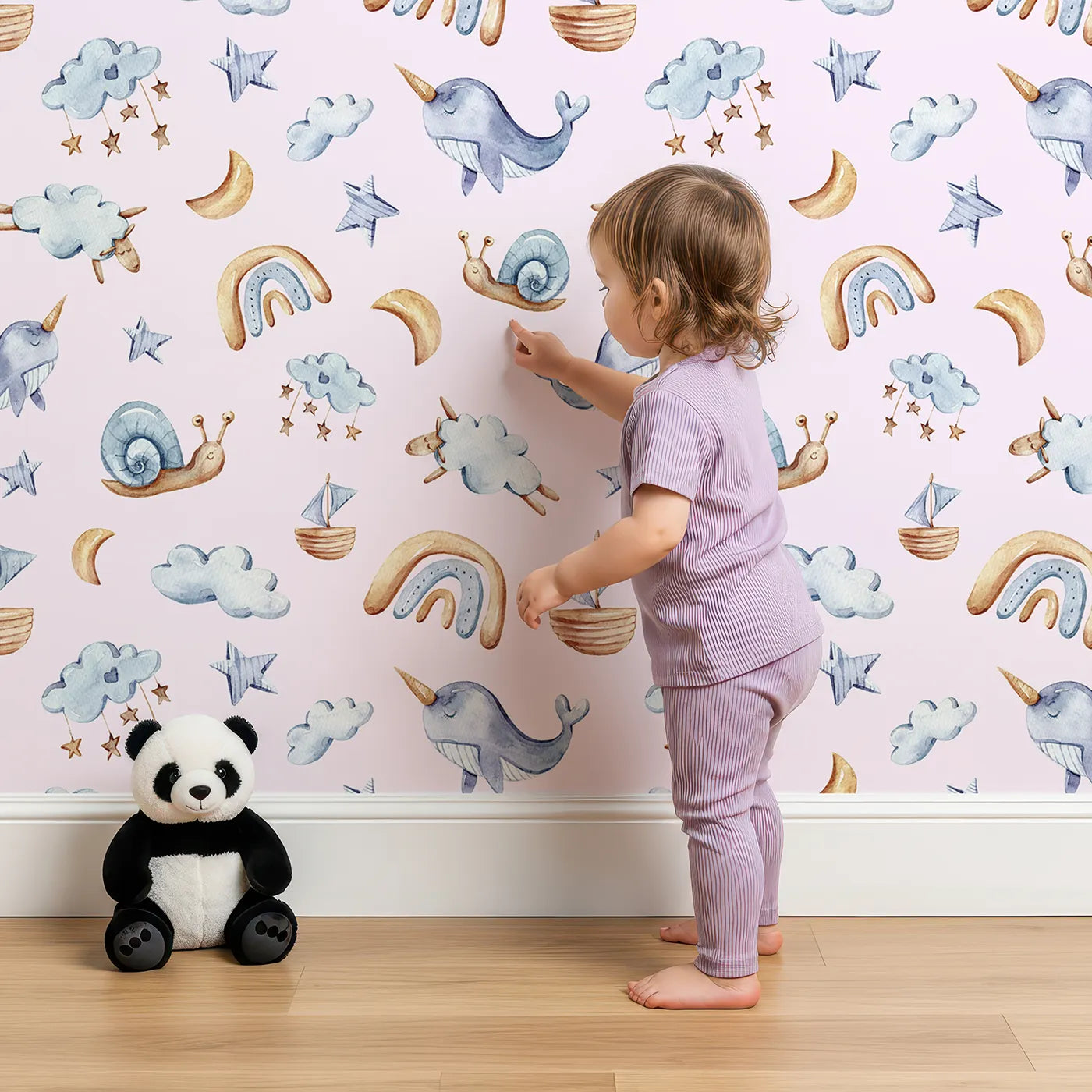 Lovely child standing in front of Whimsy Tots Sleepy Sky Parade in Pink with sheep, snail, narwhal, whale, cloud, star, moon, rainbow, sailboat in design.