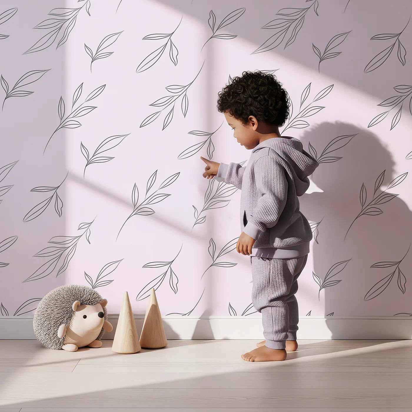 Lovely child standing in front of Whimsy Tots Line Art Leaf Dance Wallpaper in Blush Pink with leaf, branch, botanical, outline in design.