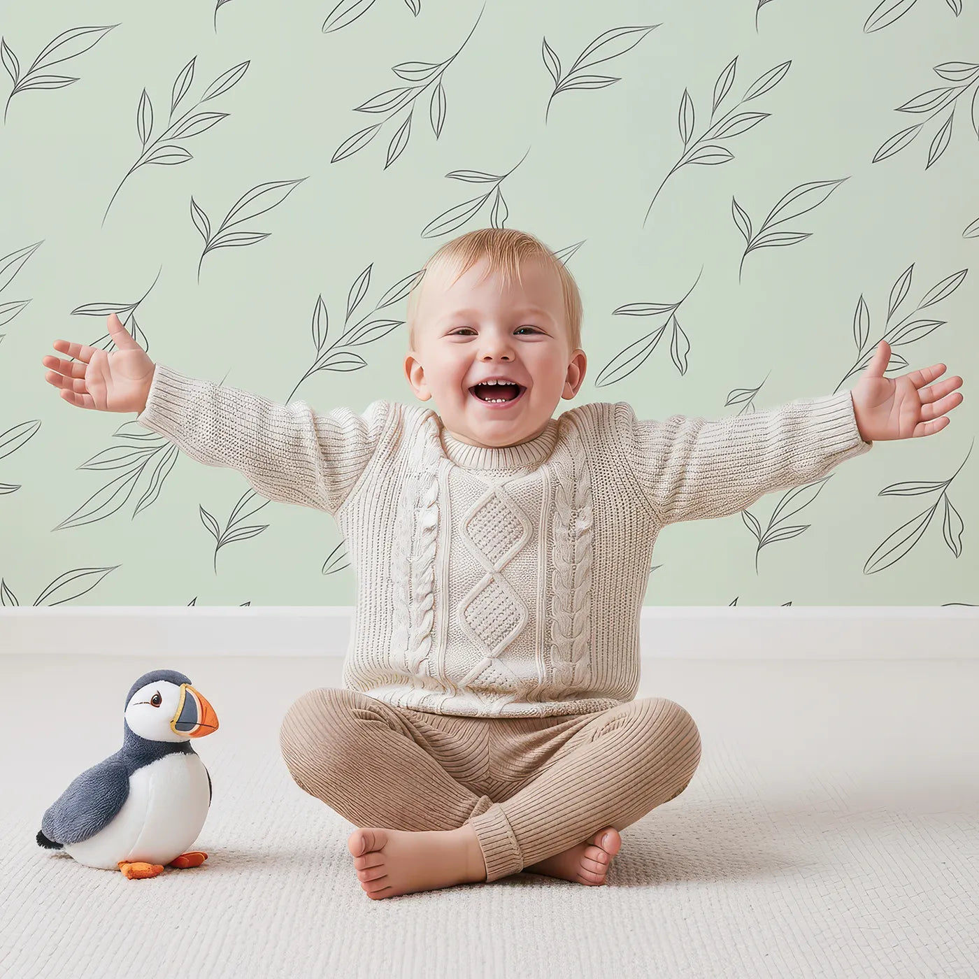 Lovely child standing in front of Whimsy Tots Line Art Leaf Dance Wallpaper in Mint Green with leaf, branch, botanical, outline in design.