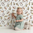 Lovely child standing in front of Whimsy Tots Botanical Numbers Garden in White with number, leaf, branch, stem in design. Lovely child standing in front of Whimsy Tots Botanical Numbers Garden in White with number, leaf, branch, stem in design.
