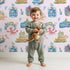 Lovely child standing in front of Whimsy Tots Seaside Story Friends in Blush Pink with octopus, turtle, whale, dolphin, fish, bottle, island, house, boat in design. Lovely child standing in front of Whimsy Tots Seaside Story Friends in Blush Pink with octopus, turtle, whale, dolphin, fish, bottle, island, house, boat in design.