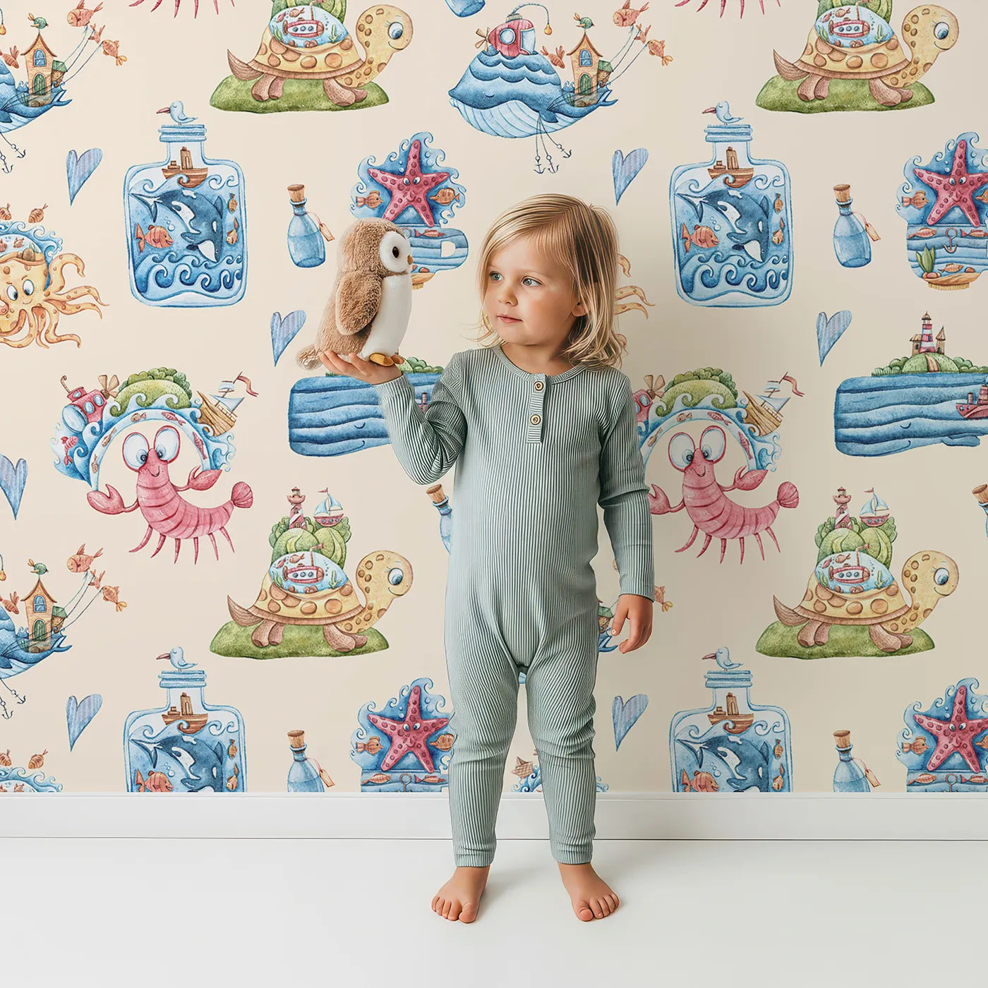 Lovely child standing in front of Whimsy Tots Seaside Story Friends in Sand with octopus, turtle, whale, dolphin, fish, bottle, island, house, boat in design.