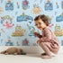 Lovely child standing in front of Whimsy Tots Seaside Story Friends in Blue with octopus, turtle, whale, dolphin, fish, bottle, island, house, boat in design. Lovely child standing in front of Whimsy Tots Seaside Story Friends in Blue with octopus, turtle, whale, dolphin, fish, bottle, island, house, boat in design.