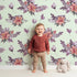 Lovely child standing in front of Whimsy Tots Berry Meadow Whispers in Mint Green with flower, petal, leaf, sprig in design. Lovely child standing in front of Whimsy Tots Berry Meadow Whispers in Mint Green with flower, petal, leaf, sprig in design.