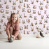 Lovely child standing in front of Whimsy Tots Rustic Alphabet Adventure in Blush Pink with letter, alphabet, tree, boat, plant in design. Lovely child standing in front of Whimsy Tots Rustic Alphabet Adventure in Blush Pink with letter, alphabet, tree, boat, plant in design.