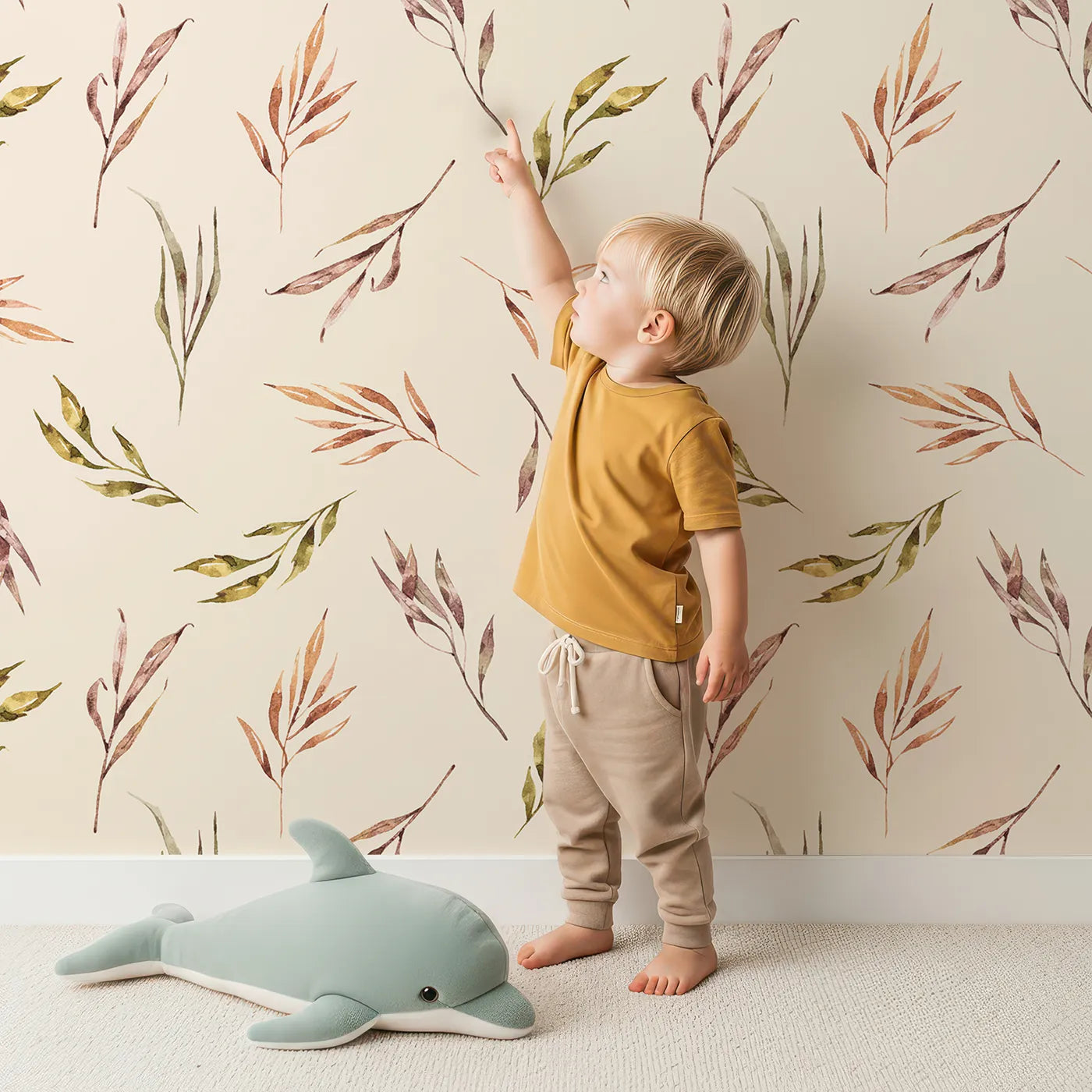 Lovely child standing in front of Whimsy Tots Sunset Meadow Breeze Wallpaper in Cream with leaf, stem, sprig, branch in design.