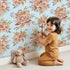 Lovely child standing in front of Whimsy Tots Autumn Bloom Harmony Wallpaper in Sky with flower, bouquet, rose, peony in design. Lovely child standing in front of Whimsy Tots Autumn Bloom Harmony Wallpaper in Sky with flower, bouquet, rose, peony in design.