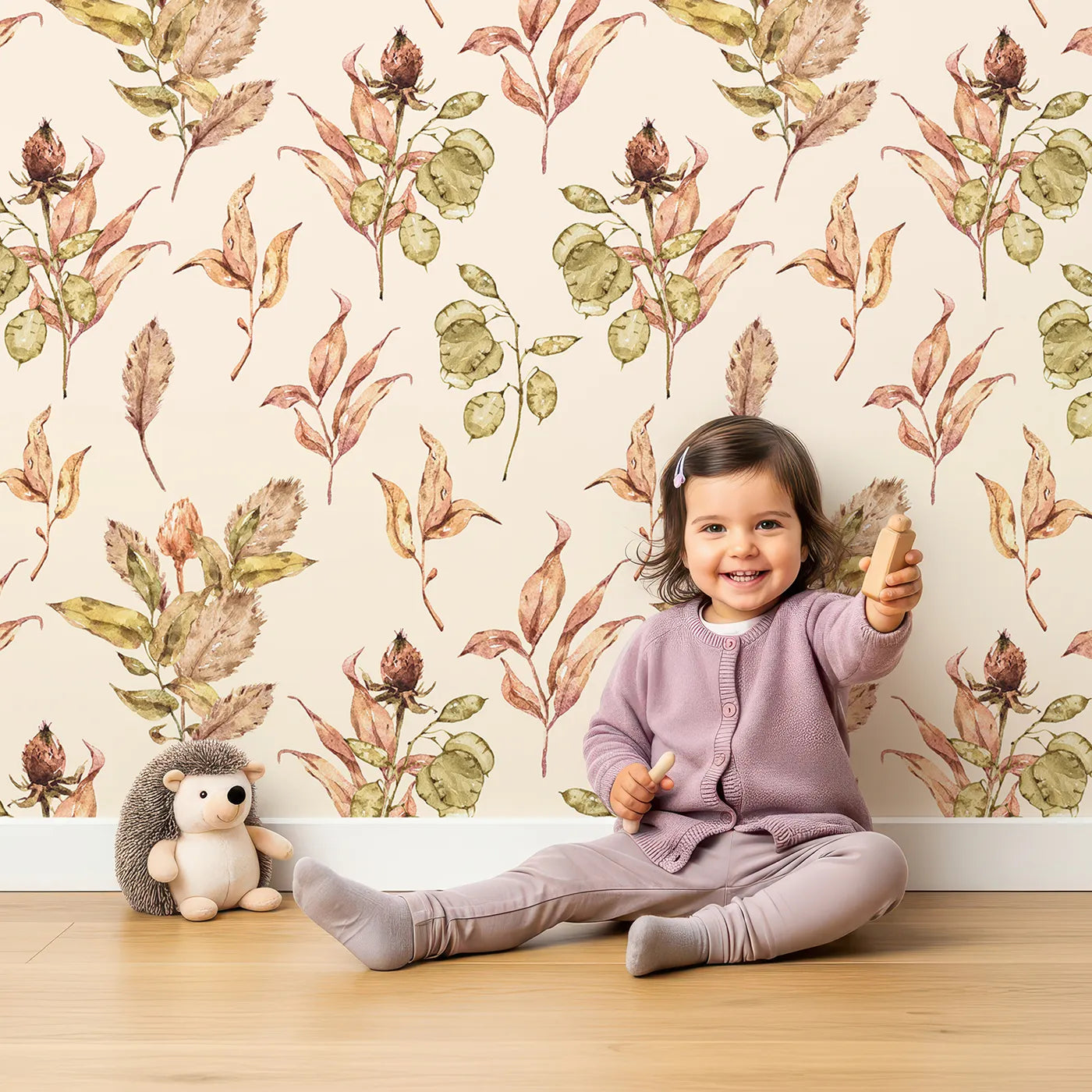 Lovely child standing in front of Whimsy Tots Autumn Forage Garden Wallpaper in Taupe Beige with leaf, pod, sprig, branch in design.