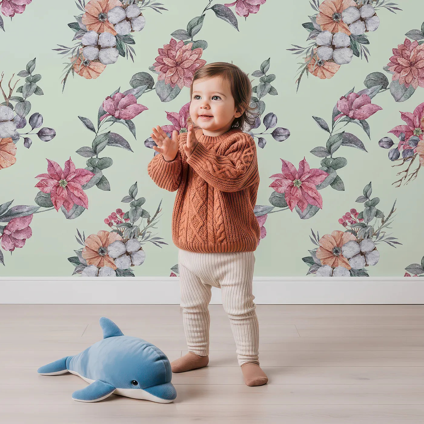 Lovely child standing in front of Whimsy Tots Winter Blooming Garden Wallpaper in Mint Green with flower, cotton, eucalyptus, poinsettia in design.