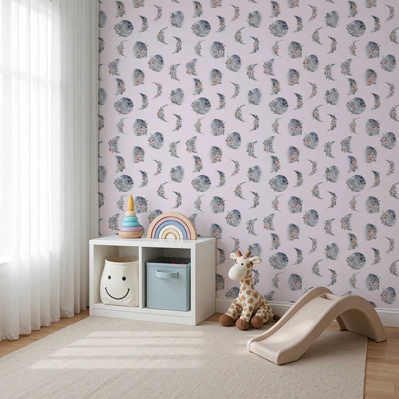 Angled view of Whimsy Tots' Celestial Winter Blooms Wallpaper in Blush Pink (W3370B).Moon phases bloom gently with winter florals on a blush sky.