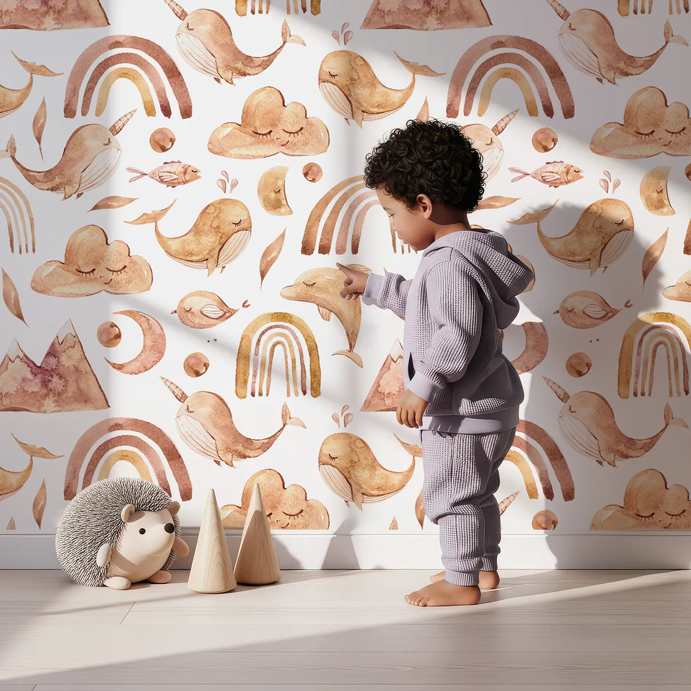 Lovely child standing in front of Whimsy Tots Whimsical Earth Friends Wallpaper in White with whale, dolphin, narwhal, bird, fish, rainbow, moon, mountain, cloud in design.