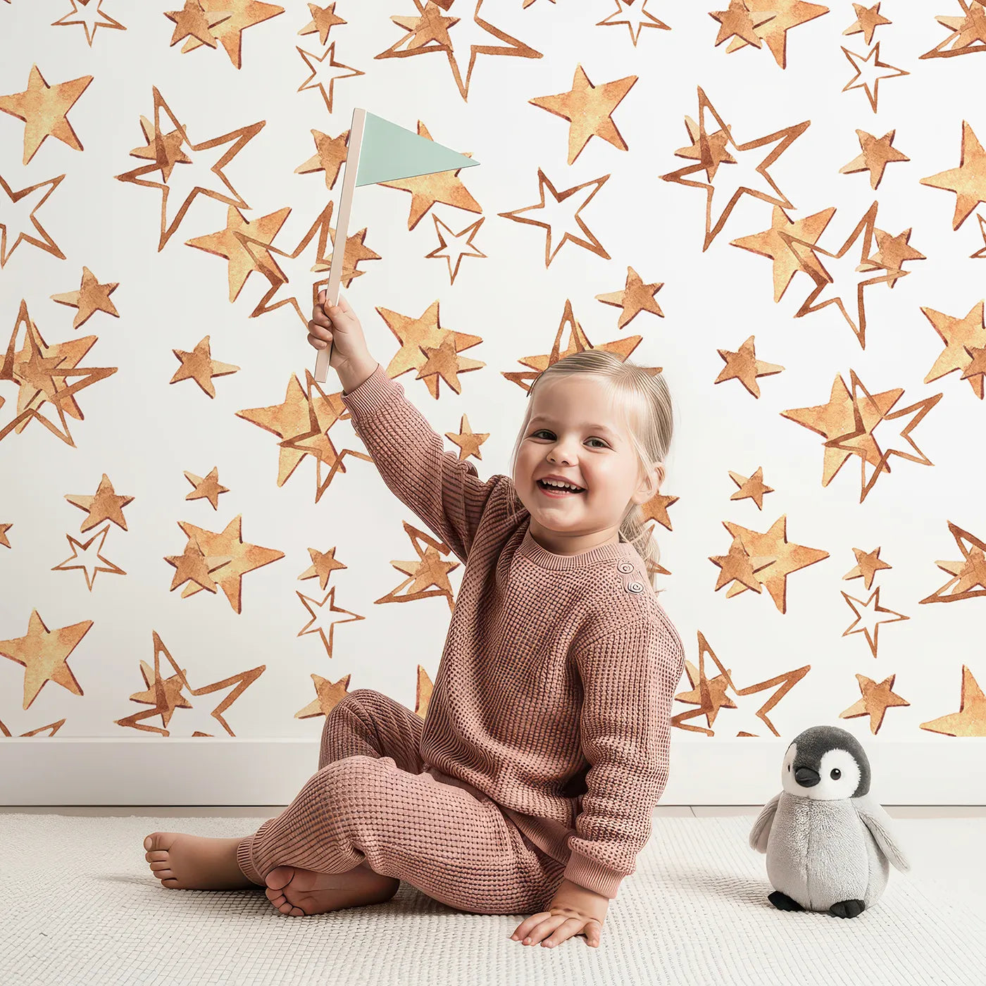 Lovely child standing in front of Whimsy Tots Golden Star Scatter Wallpaper in White with star in design.