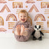 Lovely child standing in front of Whimsy Tots Sun-Drenched Shapes Wallpaper in Cream with rainbow, shape, brushstroke, line, dot in design. Lovely child standing in front of Whimsy Tots Sun-Drenched Shapes Wallpaper in Cream with rainbow, shape, brushstroke, line, dot in design.