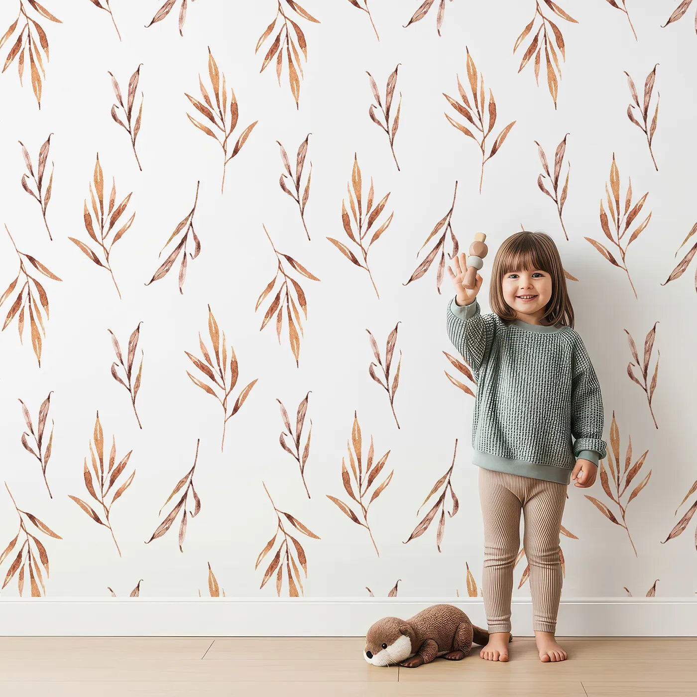 Lovely child standing in front of Whimsy Tots Rustle and Grace Wallpaper in White with branch, leaf, stem, botanical in design.