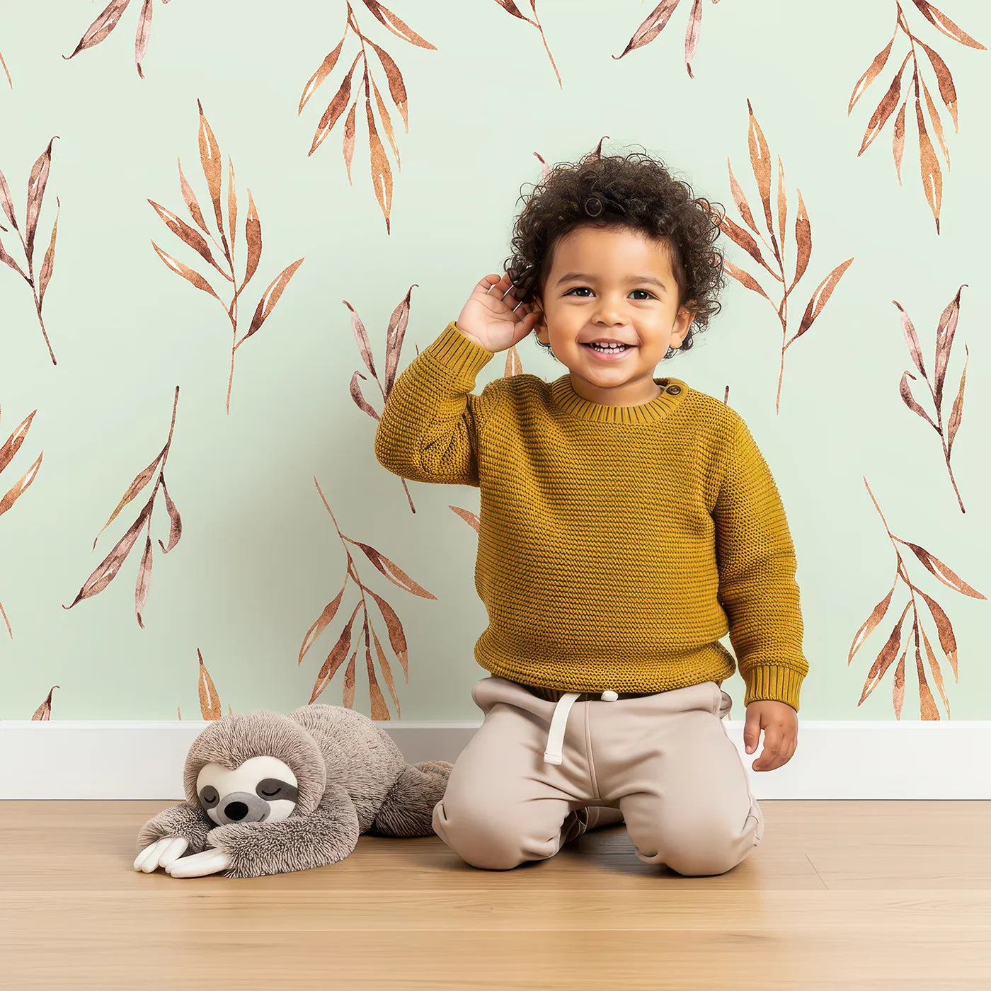 Lovely child standing in front of Whimsy Tots Rustle and Grace Wallpaper in Mint Green with branch, leaf, stem, botanical in design.